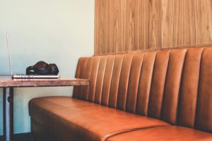 Na zdjęciu widać fragment wnętrza z tapicerowaną, skórzaną ławką w odcieniu karmelowego brązu