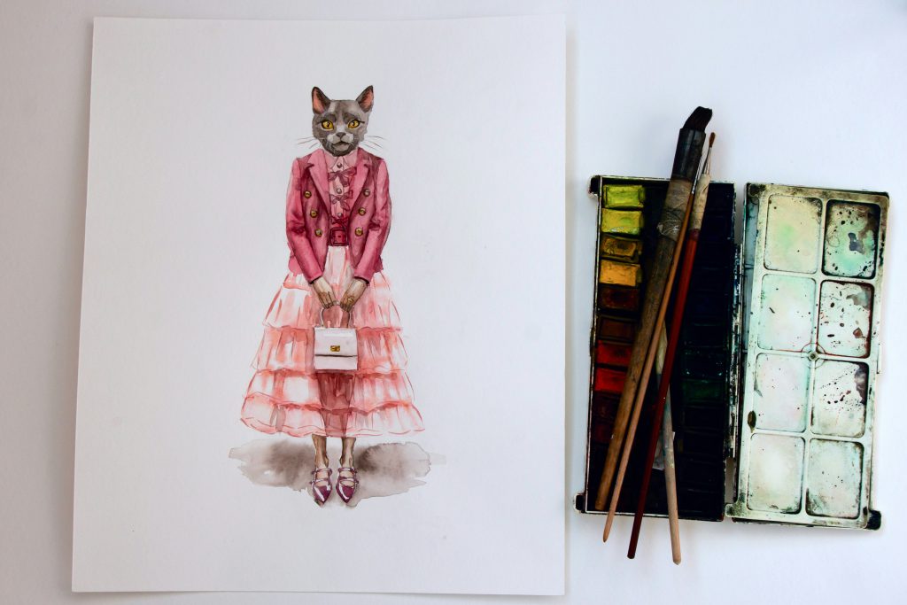 Obraz przedstawia akwarelowy portret kota ubranego w elegancki, różowy strój – marynarkę i warstwową sukienkę
