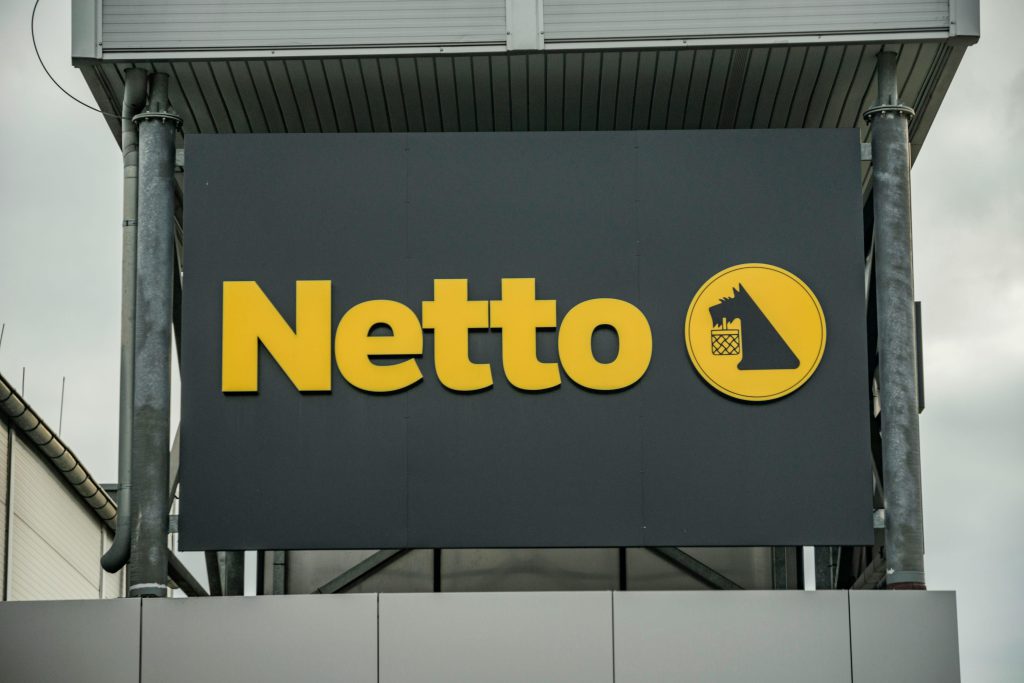 logo sklepu netto - logo na tle płyt kompozytowych
